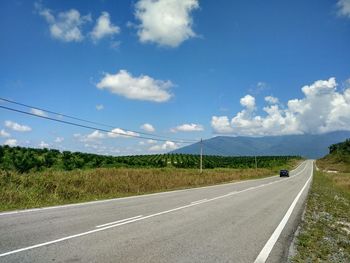 Road by landscape against sky