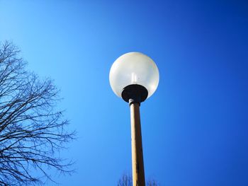 Low angle view of street light against blue sky