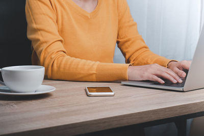 Midsection of coffee cup on table