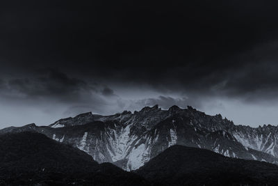 Low angle view of mountain against cloudy sky