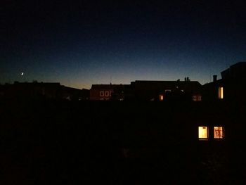 Illuminated buildings against sky at night