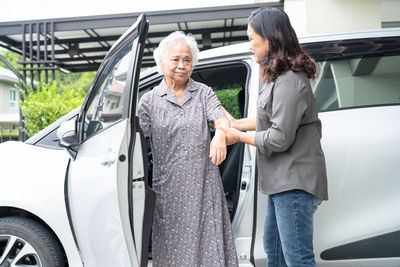 Portrait of smiling couple standing in car