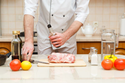 Midsection of man preparing food in kitchen