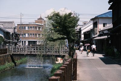 People on street amidst buildings in city