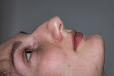 Close-up of thoughtful woman against gray background