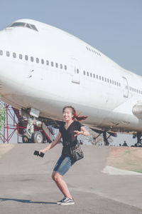 Full length of young woman sitting on airplane