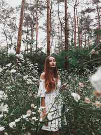 Portrait of young woman standing in forest