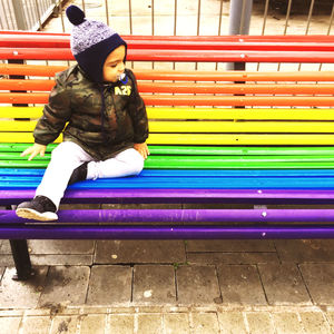 Full length of girl sitting on bench