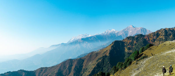 Panoramic view of snowcapped mountains against clear blue sky