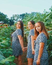 Full length of smiling woman standing against plants