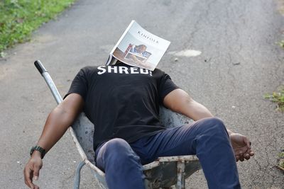 High angle view of man sitting on street