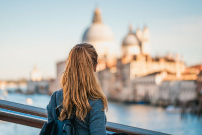 Rear view of woman looking at view while standing in city