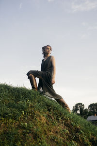 Woman in boots climbs a hill