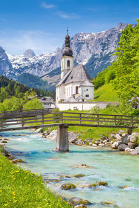 Church by building and mountains against sky