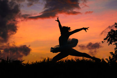 Low angle view of silhouette on jumping against sky during sunset