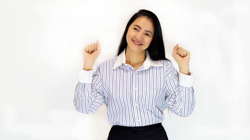 Smiling mature businesswoman gesturing against white background