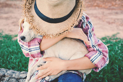 Close-up of man with dog holding hands