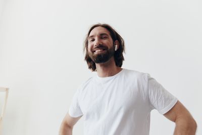 Portrait of young man standing against white background