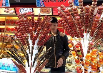 Man standing by multi colored store