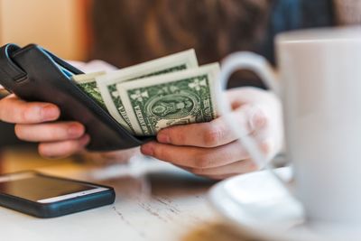 Close-up of woman using smart phone on table