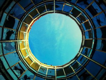 Directly below shot of blue sky seen through circular ceiling