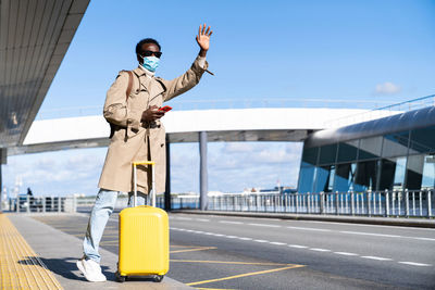 Full length of man wearing mask standing at airport