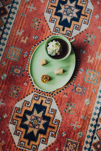 Hot chocolate with meringue in pistachio green cup and tray with mini baklava desserts