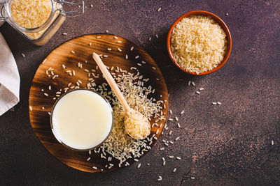 Lactose-free rice milk in a glass and rice cereal on the table top view