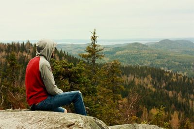 Rear view of woman sitting on mountain