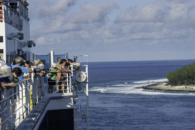 Group of people on sea against sky