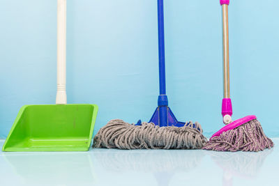 Mops by dustpan against wall