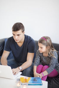 Children on sofa using laptop