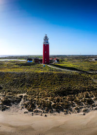 Lighthouse by sea against sky