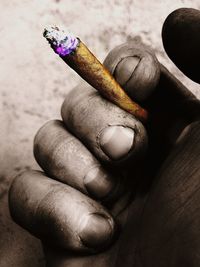 Close-up of hand holding cigarette