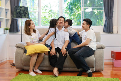 Cheerful family sitting on sofa at home