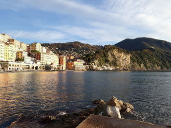 Scenic view of sea by buildings against sky