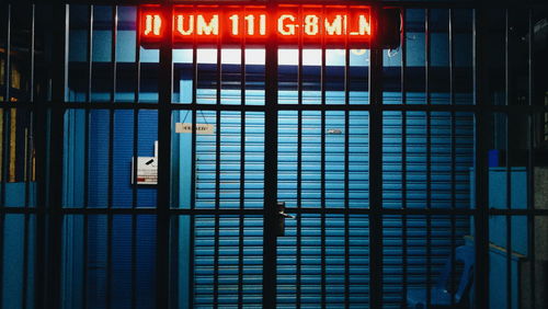 Low angle view of illuminated sign on window of building