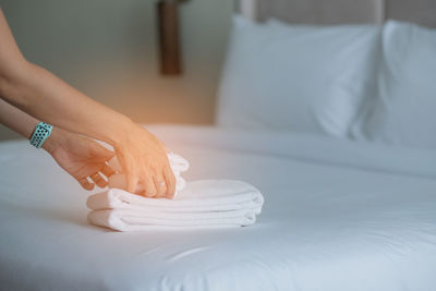 Low section of woman lying on bed at home