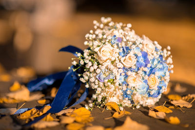 Close-up of wedding bouquet with autumn leaves on footpath