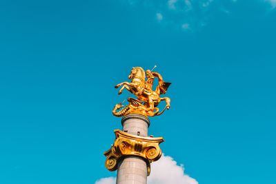 Low angle view of statue against blue sky