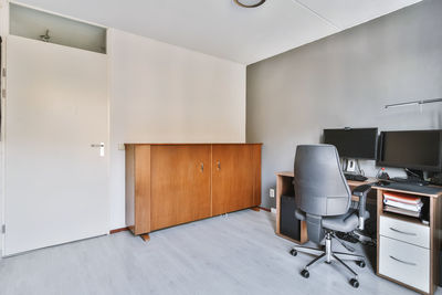 Empty chairs and table against wall