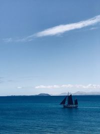 Silhouette boat on sea against blue sky