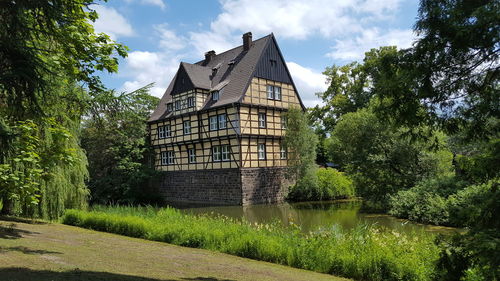 Building by river against sky