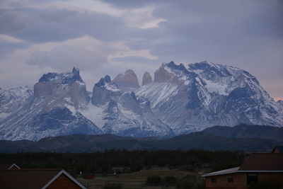 Houses by mountains against sky