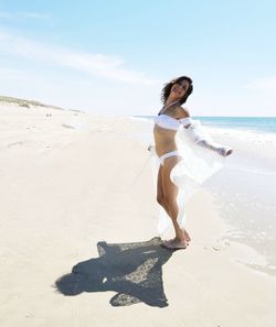 Portrait of young woman standing at beach