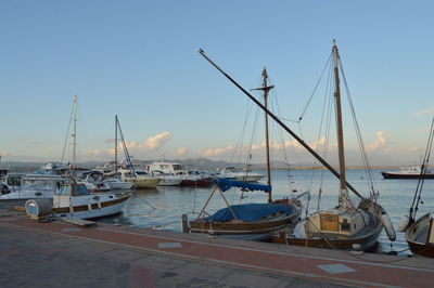 Sailboats moored in harbor
