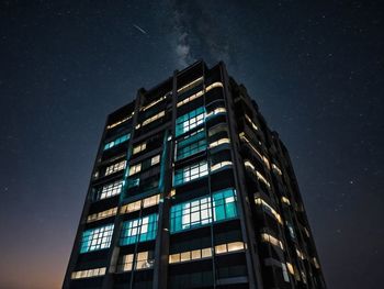 Low angle view of illuminated buildings against sky at night