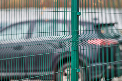 Fenced car parking lot with security. guarded territory of paid hourly parking. blurred car backdrop