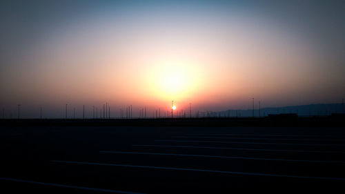 Silhouette road against sky during sunset