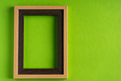 Close-up of open book against green wall